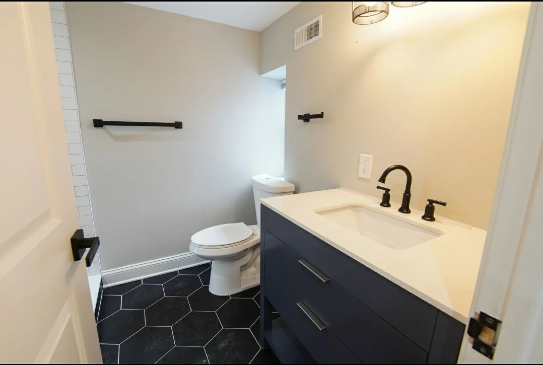 Modern bathroom with black hexagon tiles at All Good Things Recovery INC, a sober living home in Delaware.