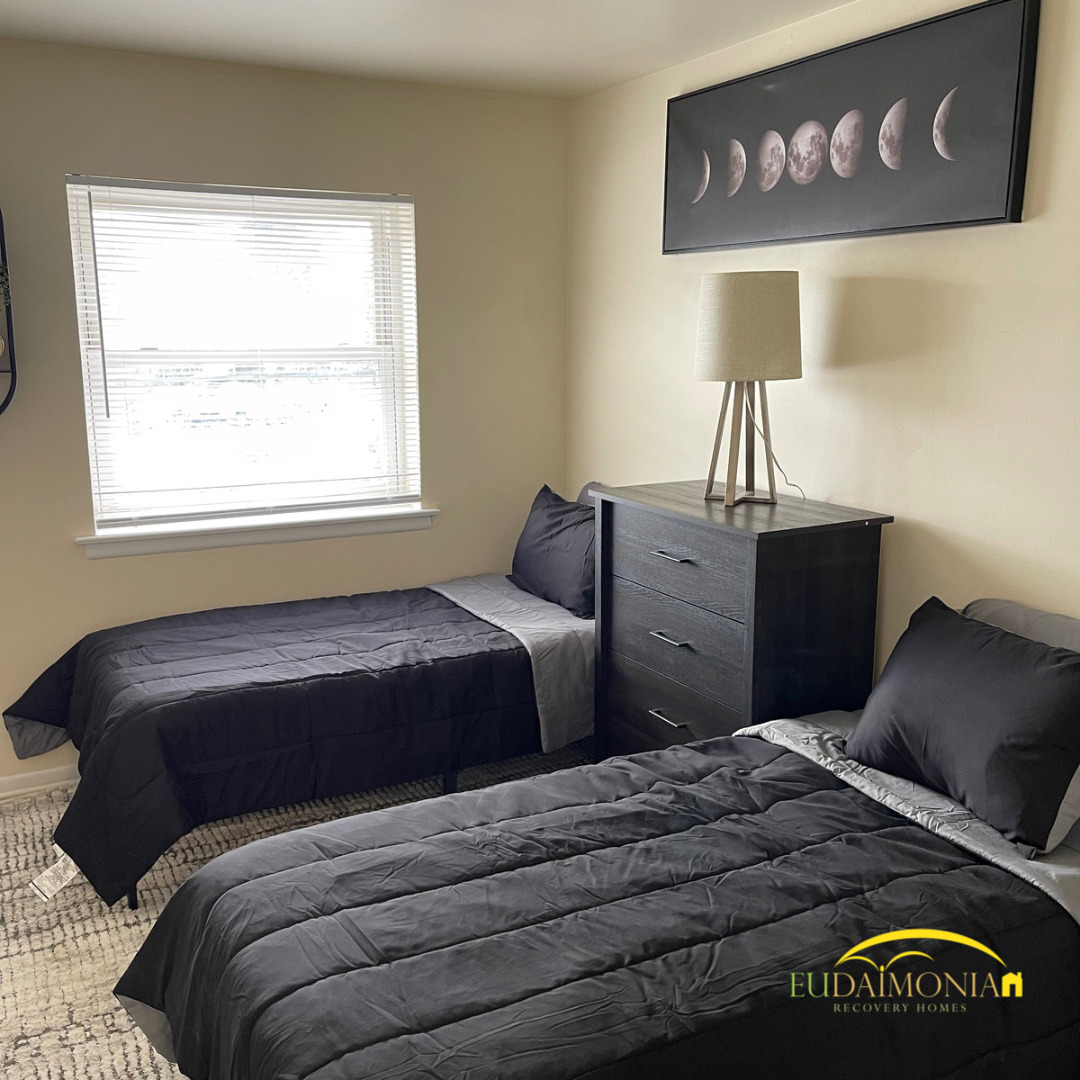 Cozy bedroom with two beds at Eudaimonia Recovery Homes sober living home in Delaware.