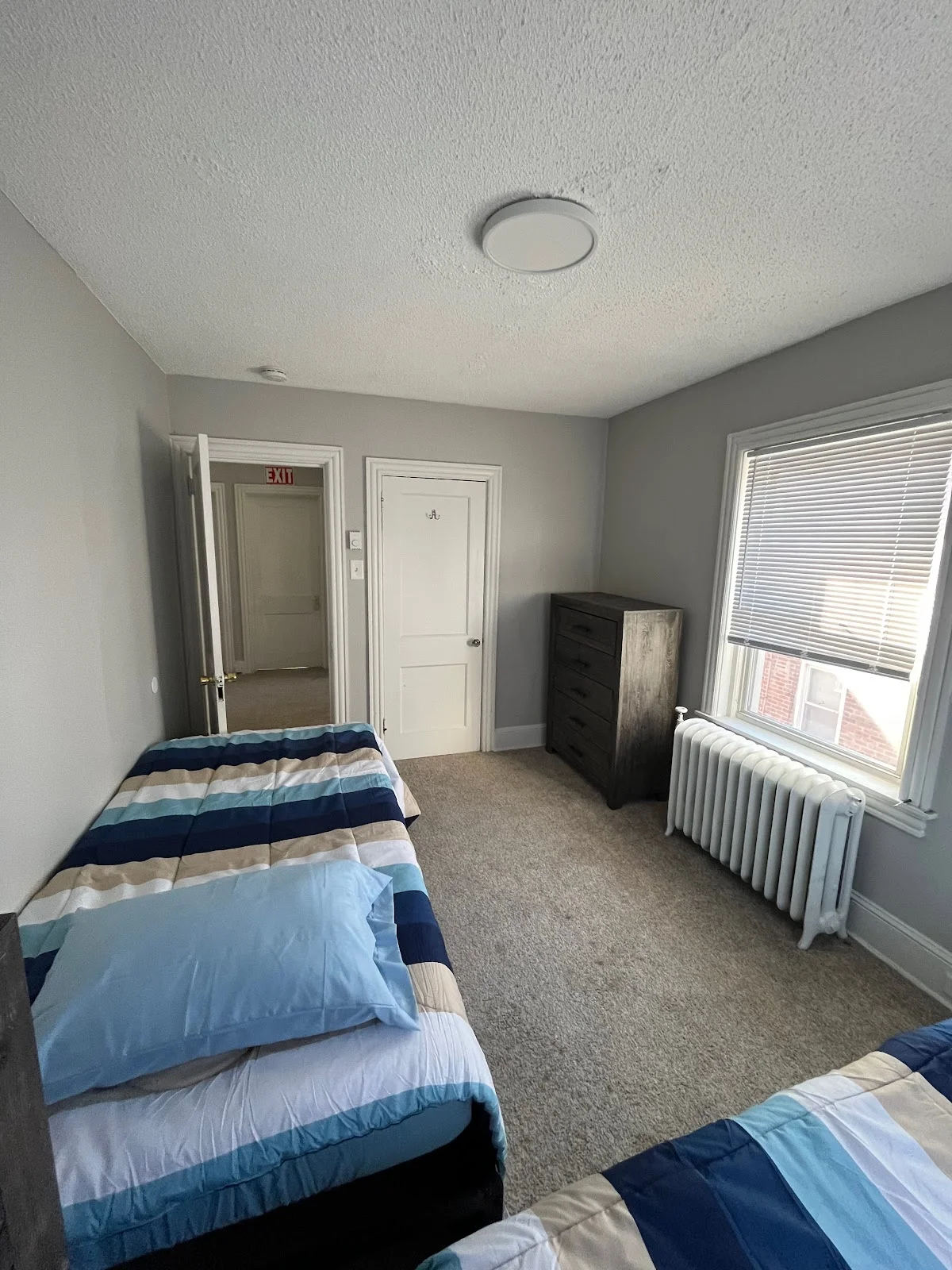 Cozy bedroom with two beds at Greenhouse Recovery, a sober living home in Delaware.