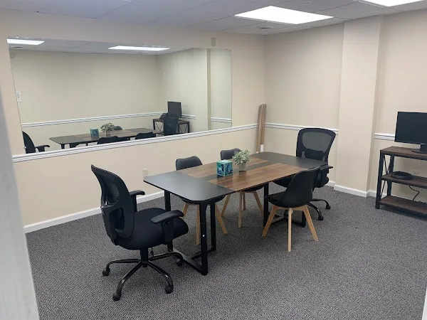 Bright meeting room with chairs and a table at SaVida Health Wilmington, a sober living home in Delaware.
