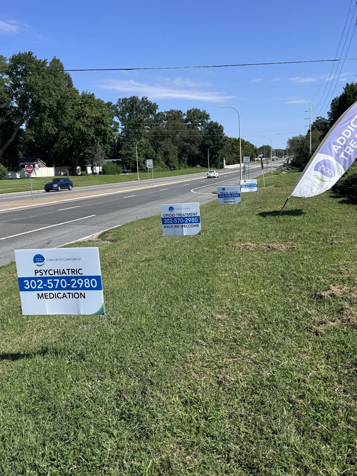 Prominent roadside signs for Concerted Care Group Dover, a sober living home in Delaware.