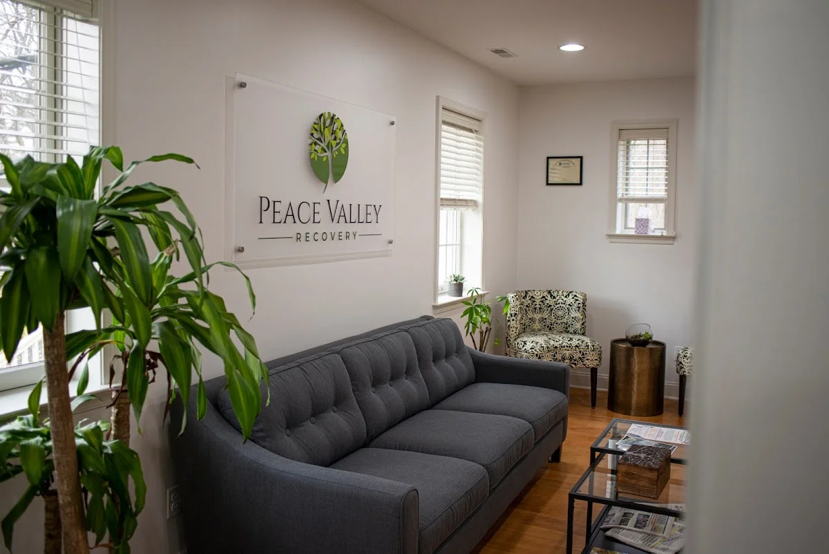 Cozy waiting area with a gray sofa at Peace Valley Recovery, a treatment center in Delaware.